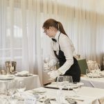 Restaurant Frau beim Tischdecken